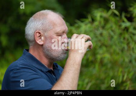 old man is drinking a softdrink Stock Photo