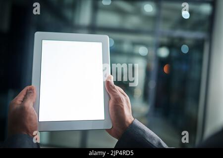 Man holding tablet in hand with blank screen over a isolated copy space background. Closeup of businessman hands on a digital tablet in a modern Stock Photo