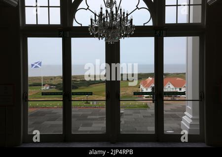 Trump Turnberry Hotel,Turnberry, Ayrshire,  Scotland UK. View from the interior overlooking the golf course. The large Scottish flag a saltire can be seen framed by the window with the club house on the right of the photo Stock Photo