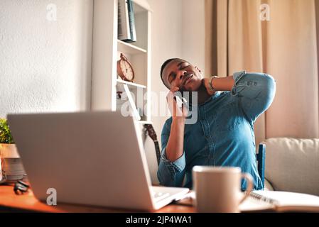 Tired business man with neck pain on a laptop and phone call, looking stressed and stretching bad, strained muscle or sore back. Stressed Stock Photo