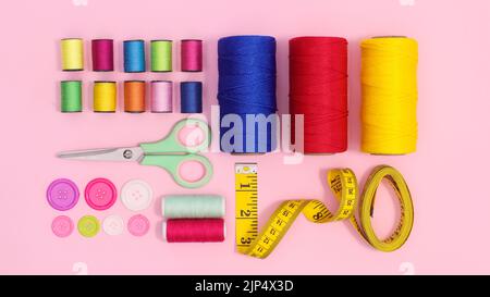 Sewing asccessories arrangement on pastel pink background. Flat lay. Stock Photo