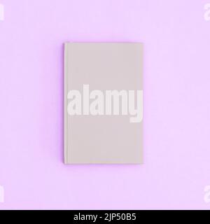 Grey hardcover vintage book on pastel purple background. Flat lay copy space Stock Photo