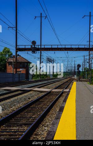 Perryville, MD, USA – August 13, 2022: Electrified railroad tracks at the MARC Rail Station. Stock Photo