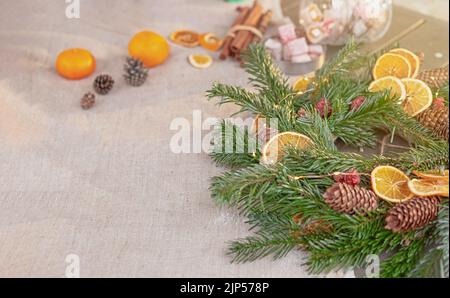 Wide banner with natural spruce wreath on a fabric tablecloth Stock Photo