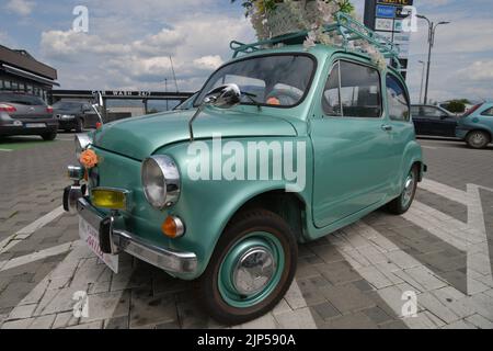 The legendary car supermini Zastava 750 (Fiat 600) which was produced from 1955 to 1985 parked in the front of the flower shop, decorated with flowers Stock Photo