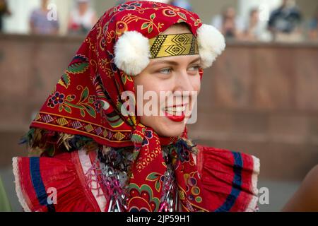 Moscow, Russia. 15th of August, 2022. A woman presents peasant Russian national costumes during the Round Dances of Russia festival on the square of the VDNKh Exhibition Center against the background of the Central Pavilion in Moscow, Russia Stock Photo
