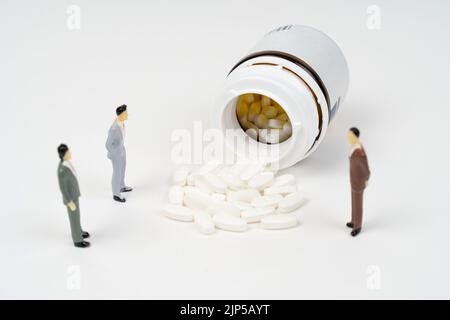 Miniature people toy figure photography. A old man walking with stick or crutch, in the middle of medicine pills. Medical access concept. Image photo