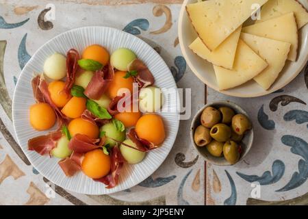 Spanish tapas, melon and ham, olives and cheese Stock Photo
