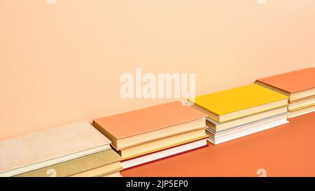 Creative hardcover vintage books on two shade orange background. Flat lay Stock Photo