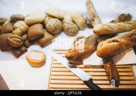 Different types of bread on the table in the kitchen. Stock Photo