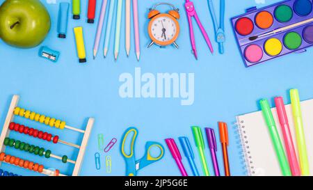 Back to school copy space on pastel blue background with school stationery arrangement. Flat lay Stock Photo