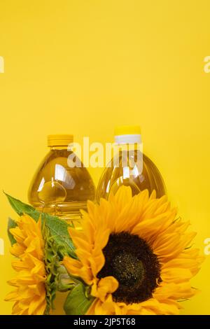 Sunflower oil. Oil bottles and sunflowers on a bright yellow background.Organic natural farm sunflower oil. Edible oils. Stock Photo