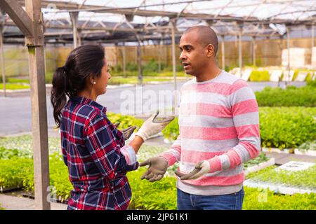 Two latino garden workers discussing working process Stock Photo