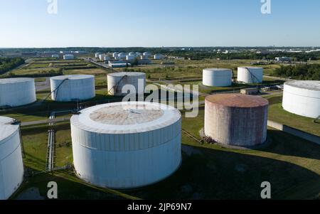 An aerial view looking at a large field of crude oil storage tanks, seen a sunny day. Stock Photo