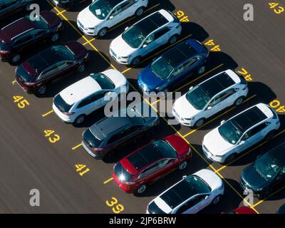 An aerial view above a parking lot at a Ford Motor Company plant. Rows of newly manufactured Ford Edge SUVs are seen on a sunny day. Stock Photo