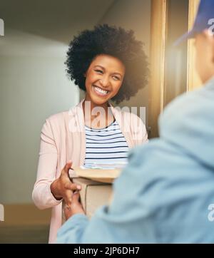 Thank you for getting it to me so quickly. a young woman receiving her delivery from the courier. Stock Photo