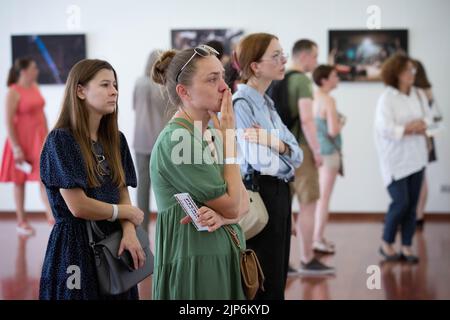 Kyiv, Ukraine. 14th Aug, 2022. People watch pictures by Azov soldier-photographer Dmytro 'Orest' Kozatsky shown at exhibition titled 'Unprecedented Azovstal' in Kyiv. Photographies by Dmytro 'Orest' Kozatsky show the realities of Azov regiment soldiers sieged at Azovstal steel plant in Mariupol. Before being captured Kozatsky published his pictures on social networks in order to spread them as widely as possible. (Photo by Oleksii Chumachenko/SOPA Images/Sipa USA) Credit: Sipa USA/Alamy Live News Stock Photo