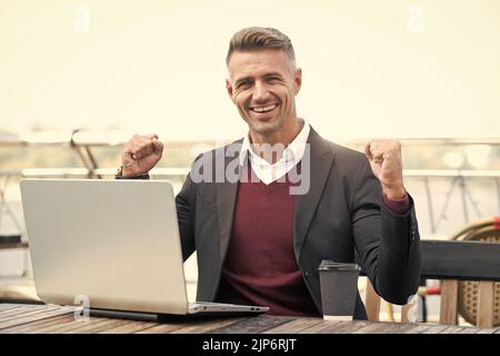 You can win. Happy businessman make winning gesture. Creating winning e-business Stock Photo