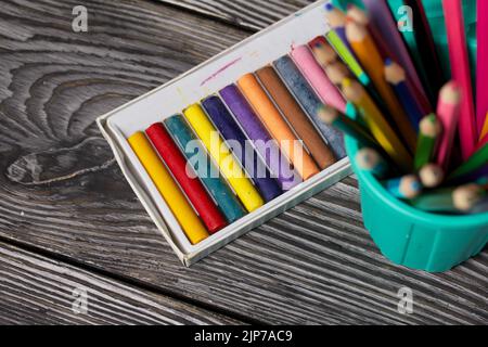 Colored pencils and pastels for drawing.  focus on pastels. On pine boards.  Top view Close-up. Stock Photo