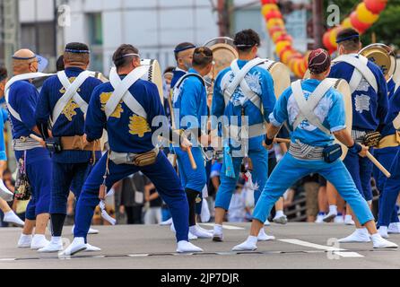 Tokushima, Japan - August 12, 2022: Taiko drummers wearing blue uniforms perform on street at Awaodori festival Stock Photo