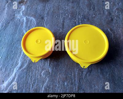 yellow plastic container box on stone background Stock Photo