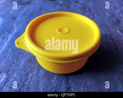 yellow plastic container box on stone background Stock Photo