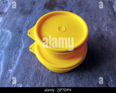 yellow plastic container box on stone background Stock Photo