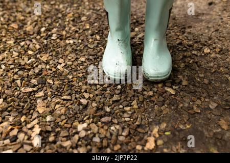 Close up of dirty white rubber boots on ground Stock Photo