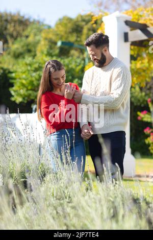 Happy caucasian couple having fun, laughing in sunny garden Stock Photo