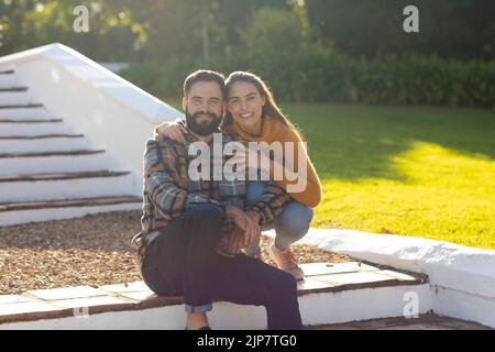 Image of happy caucasian couple posing in autumn garden Stock Photo