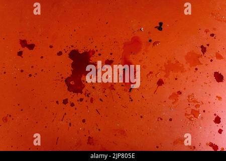 Dark red dirty stains from liquid or blood on red linoleum. Stock Photo