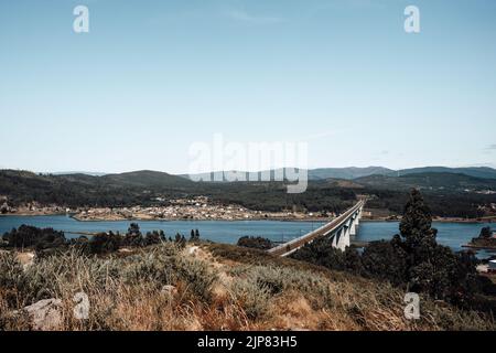 Train tracks on a bridge over the river with a forest on the foreground Stock Photo