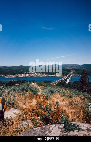 Train tracks on a bridge over the river with a forest on the foreground Stock Photo