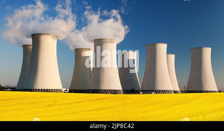 Panoramic view of Nuclear power plant Jaslovske Bohunice with golden flowering field of rapeseed - Slovakia - two possibility for production of electr Stock Photo