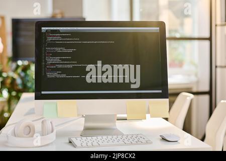 Close-up of computer monitor with codes on the screen on table at office Stock Photo
