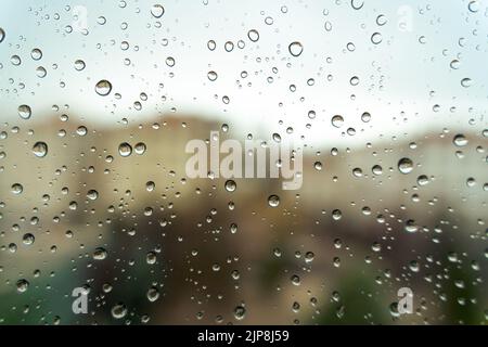 Raindrops on window, blurry background. Close-up view. Stock Photo