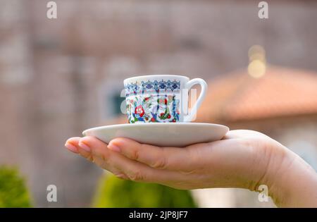 Turkish coffee cup on the palm on traditional turkish architecture background Stock Photo