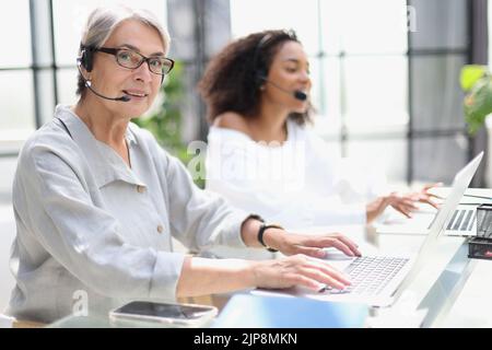 operator woman agent with headsets working in a call centre Stock Photo