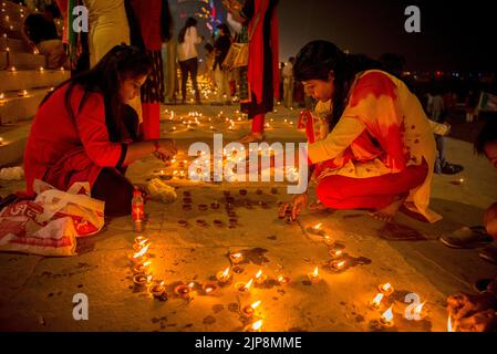 Women lighting oil lamps on Dev Deepavali, Varanasi, Banaras, Benaras, Kashi, Uttar Pradesh, India Stock Photo