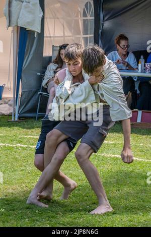 Two young teenagers brothers competing in the Grand Cornish Wrestling Tournament on the picturesque village green of St Mawgan in Pydar in Cornwall in Stock Photo