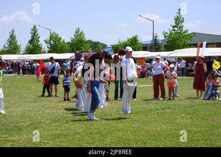 People and kids having fun at gunnysack race in summer outdoor Stock Photo