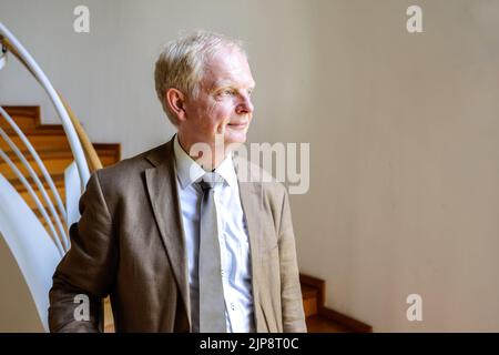 16 August 2022, Schleswig-Holstein, Schleswig: Rainer Hering, Senior Archive Director of the Schleswig-Holstein State Archives, looks out of a window for a portrait photo. On August 17, 2022, the exhibition 'Heinz Reinefarth. From Nazi War Criminal to Member of the State Parliament' will open. Reinefarth was a German lieutenant general in the Waffen SS and was responsible for, among other things, the suppression of the Warsaw Uprising, in which tens of thousands of civilians were shot under his command. Reinefarth was never prosecuted for his actions. He managed to embark on a political career