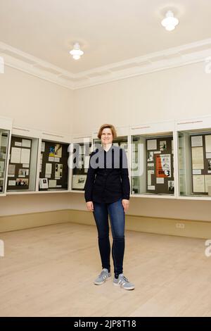 16 August 2022, Schleswig-Holstein, Schleswig: Julia Liedtke, curator at the Schleswig-Holstein State Archives, stands in front of display cases. On August 17, 2022, the exhibition 'Heinz Reinefarth. From Nazi War Criminal to Member of the State Parliament' will open. Reinefarth was a German lieutenant general in the Waffen SS and was responsible for, among other things, the suppression of the Warsaw Uprising, in which tens of thousands of civilians were shot under his command. Reinefarth was never prosecuted for his actions. He managed to embark on a political career, becoming a member of the