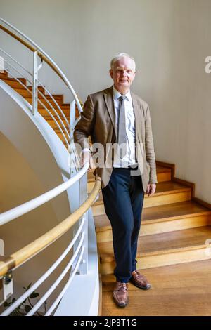 16 August 2022, Schleswig-Holstein, Schleswig: Rainer Hering, Senior Director of Archives at the Schleswig-Holstein State Archives, stands for a portrait photo on a staircase railing. On August 17, 2022, the exhibition 'Heinz Reinefarth. From Nazi War Criminal to Member of the State Parliament' will open. Reinefarth was a German lieutenant general in the Waffen SS and was responsible for, among other things, the suppression of the Warsaw Uprising, in which tens of thousands of civilians were shot under his command. Reinefarth was never prosecuted for his actions. He managed to embark on a poli Stock Photo