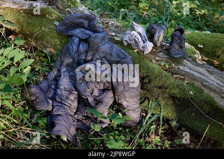 Puszcza Bialowieska, Poland. 16th Aug, 2022. Worn out clothing abandoned by Said, refugee from Congo (DRC) who was wandering in the woods for 4 days avoiding Polish border patrols. After getting new clothes, food from Fundacja Ocalenie activists (NGO supporting immigrants) he is hitting the road again to the area with a mobile signal to call sister in Germany to arrange the last leg of this refugee journey. He still hides avoiding authorities and forceful pushback to Belarus. NGOs work in the border forests in very hard conditions but also tough legal situation. They provide food, medical aid Stock Photo