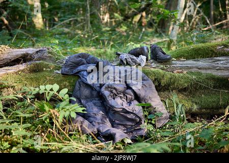 Puszcza Bialowieska, Poland. 16th Aug, 2022. Worn out clothing abandoned by Said, refugee from Congo (DRC) who was wandering in the woods for 4 days avoiding Polish border patrols. After getting new clothes, food from Fundacja Ocalenie activists (NGO supporting immigrants) he is hitting the road again to the area with a mobile signal to call sister in Germany to arrange the last leg of this refugee journey. He still hides avoiding authorities and forceful pushback to Belarus. NGOs work in the border forests in very hard conditions but also tough legal situation. They provide food, medical aid Stock Photo