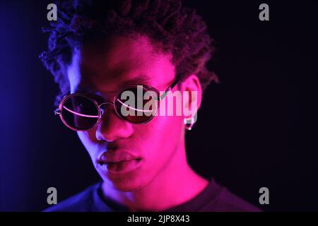 African American man portrait in sunglasses, isolated on purple background Stock Photo