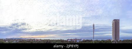 Long panorama banner. Light soft blue orange sunrise reflections dramatic sky cumulus clouds. Early rising in the city. High skyscraper multi-storey Stock Photo