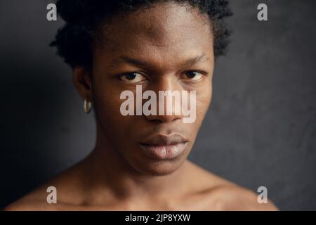 young african american man with serious expression on black background. copy space Stock Photo