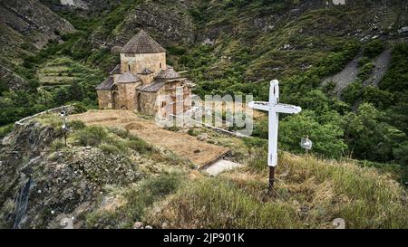 (EDITORS NOTE: Image taken with drone)Aerial view of Ateni Sioni Church in Shida Kartli, Georgia with a white cross on the foreground.  The Ateni Sioni Church is an early 7th-century Georgian Orthodox church in the village of Ateni, some 10 km south of the city of Gori, Georgia. Stock Photo